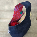 Blue denim bag with a colorful interior on a beige surface