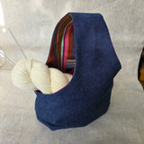 Denim bag with colourful interior on a neutral background