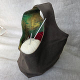 Khaki canvas bag with earth-tone interior on a neutral background