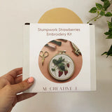 Stumpwork Strawberries Embroidery Kit packaging held by a hand with a plant in the corner.